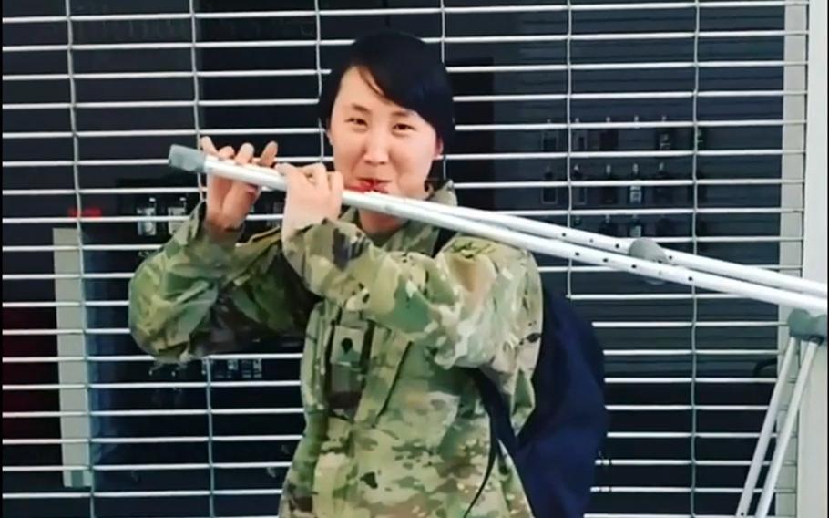 In a screenshot from Instagram, Spc. Jessica Tang plays a song on a crutch she modified like a flute, after sustaining a serious injury during basic training.
