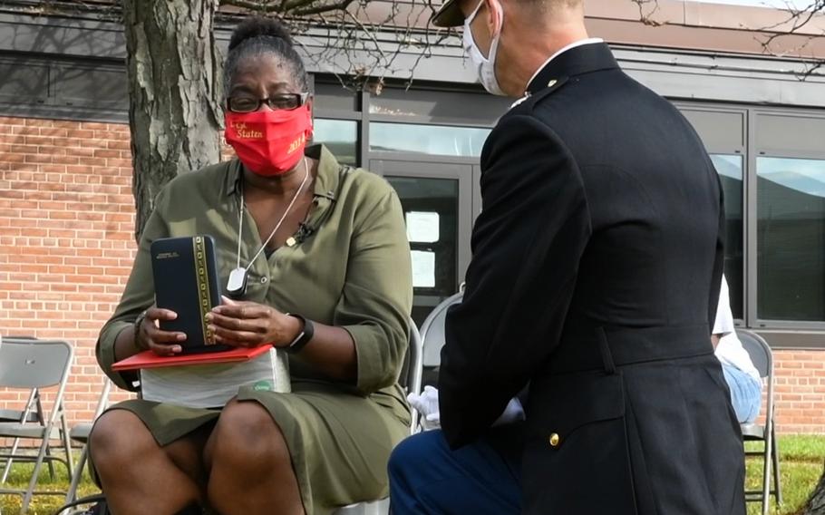 A U.S. Marine Corps major with 4th Combat Engineer Battalion presents Lance Cpl. Corey Staten's mother, Nancy Staten, the Navy and Marine Corps Medal during an award ceremony in Baltimore, Md., Oct. 24, 2020. Lance Cpl. Staten was awarded the medal for saving another Marine's life in 2018.