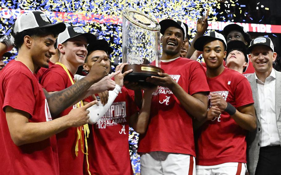 Alabama players pose with the trophy after an NCAA college basketball game against Texas A&M in the finals of the Southeastern Conference Tournament, Sunday, March 12, 2023, in Nashville, Tenn. Alabama won 82-63. 
