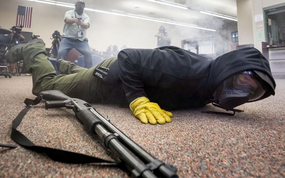 Taylor County sheriff's deputy Brad Gailey falls to the ground as he portrays an active shooter while pursued by two school marshals during a school safety training demonstration in Round Rock. Officials from Texas Commission on Law Enforcement say more districts are inquiring about the program that allows teachers and school staff to carry guns on campus. 
