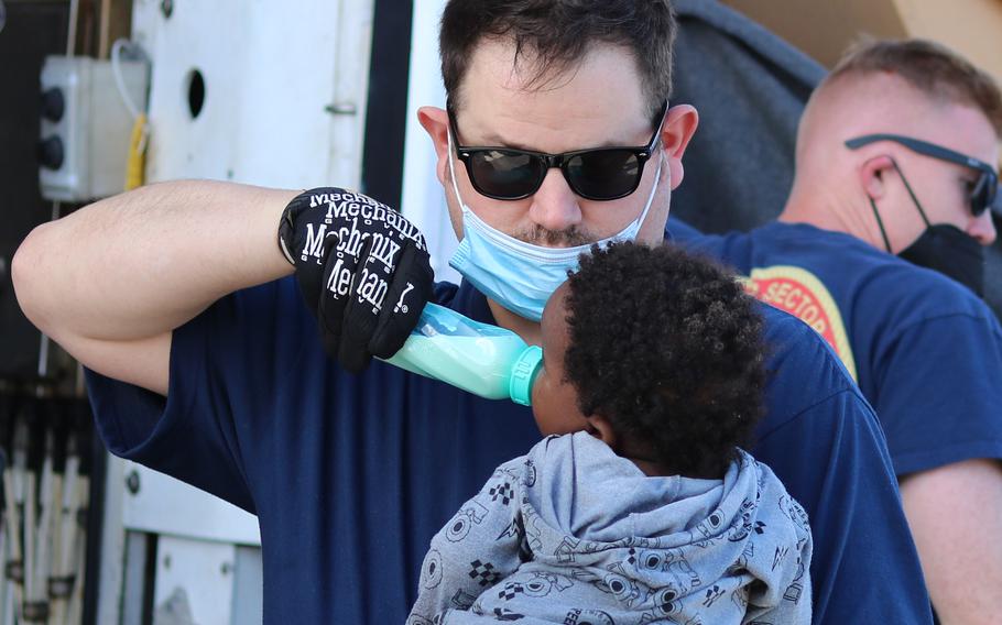 Coast Guard Cutter Campbell’s crew member feeding a baby near Anguilla Cay, Bahamas, April 11, 2022. Coast Guard Cutter Charles Sexton's crew transferred 67 Haitians to Bahamian authorities after the Cutter Campbell crew stopped them. 