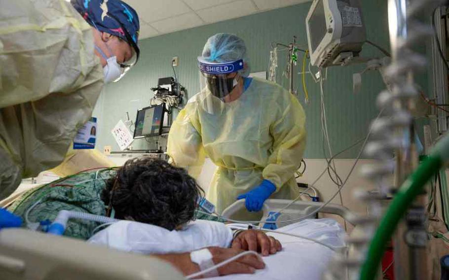 Nurses Assistant Vanessa Gutierrez, left, and Jamie McDonough, RN, talk to a COVID-19 patient in the COVID ICU at St. Joseph Hospital in Orange, CA, on Wednesday, July 21, 2021. As of July 14, 2022, the number of COVID patients in California hospitals has more than quadrupled since mid-April. Doctors who treat these patients are seeing consistent indications that, for most, the disease is less severe than in earlier surges of the deadly virus that killed more than a million Americans. 