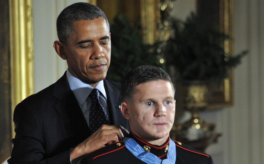 President Barack Obama awards the Medal of Honor to retired Marine Corps Cpl. Kyle Carpenter at the White House, June 19, 2014. In the background is Vietnam War MOH recipient Brian Thacker.