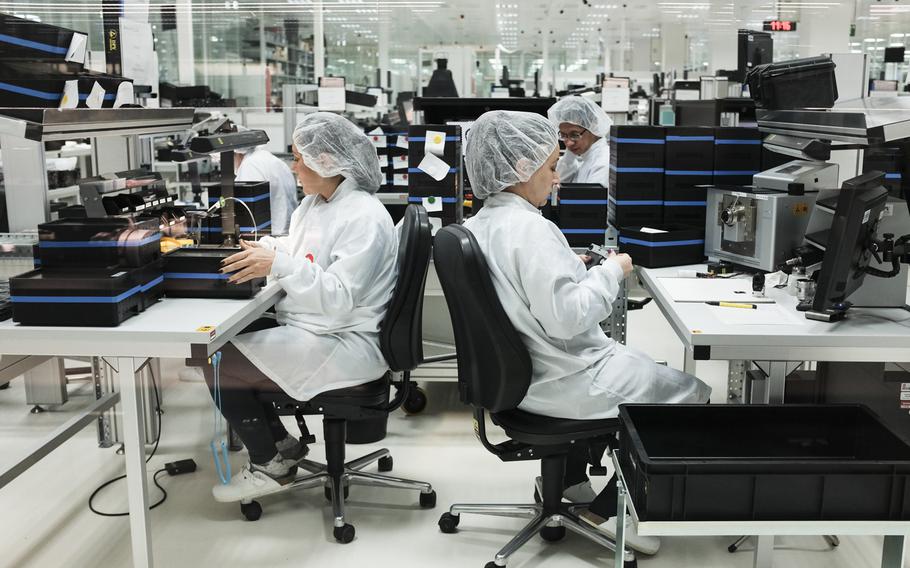 Leica employees can be viewed through windows as they build cameras and lenses at the Leica manufacturing and administrative complex in Wetzlar, Germany, Jan. 6, 2015.

