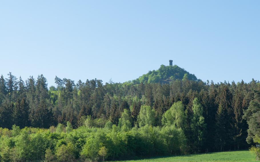 The observation tower at the summit of the Rauher Kulm mountain, near Grafenwoehr, Germany, as seen from the roadway leading up to the base of the mountain. 

