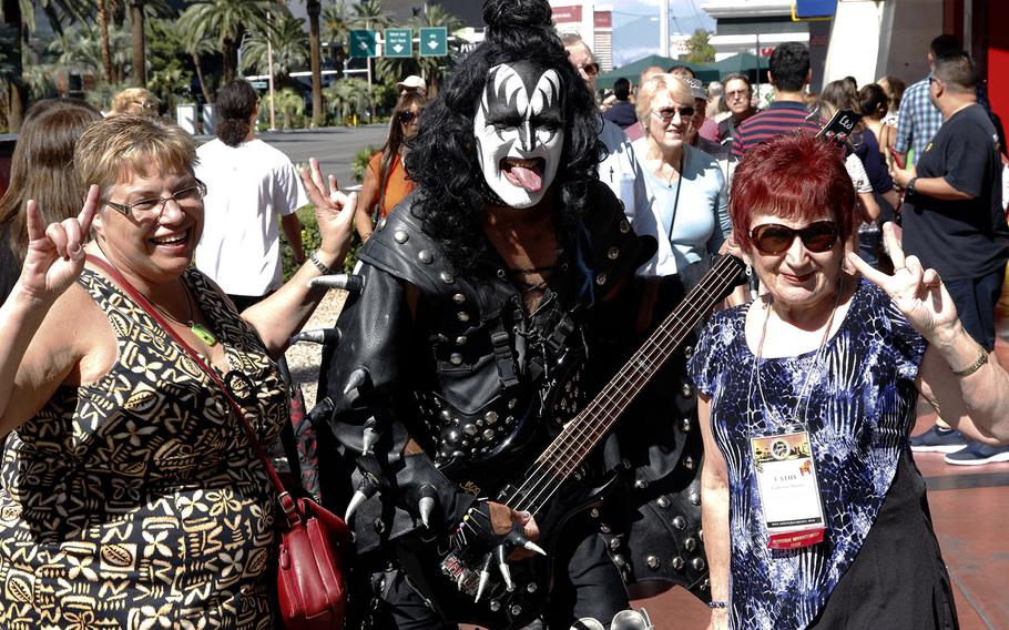 Tourists outside the Hard Rock Cafe on the Las Vegas Strip pose with a Gene Simmons (Kiss) impersonator.