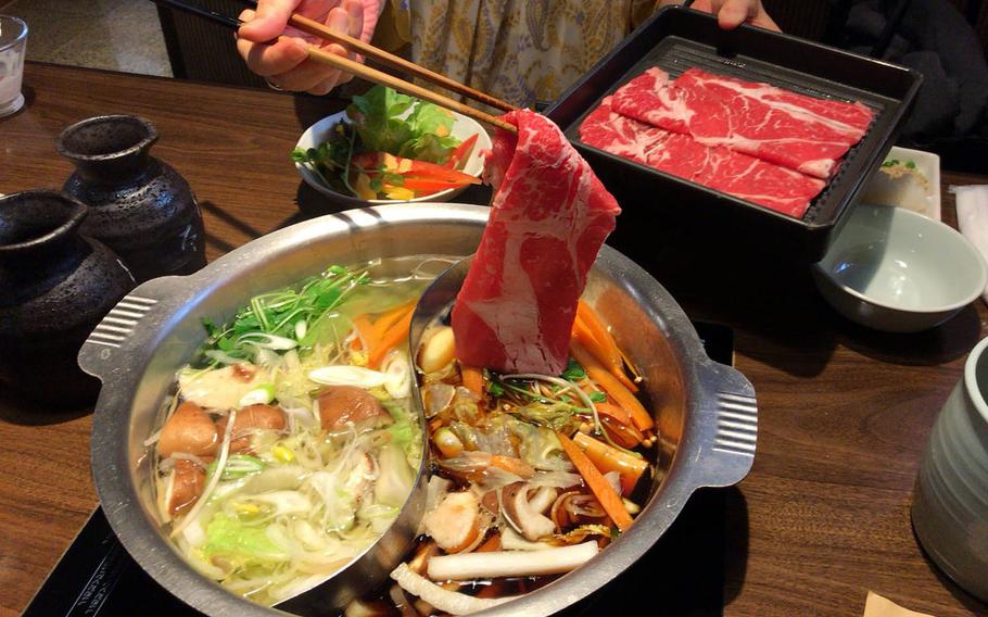 Beef, pork and vegetables are cooked in the hot pot with sukiyaki and shabu shabu soup at Nabezo in Shibuya, Tokyo. 