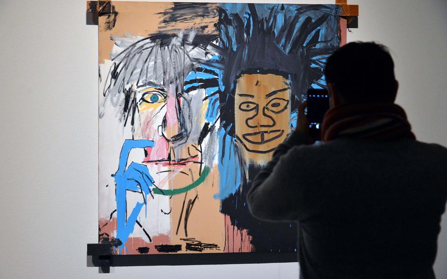 A man photographs Jean-Michel Basquiat's ''Dos Cabezas,'' one of the works on display at the ''Basquiat. Boom for Real'' exhibit at the Schirn Kunsthalle in Frankfurt, Germany, during a media viewing event. The two heads are Andy Warhol and Basquiat. The exhibit runs until May 27, 2018.  Artworks: © VG Bild-Kunst Bonn, 2018 & The Estate of Jean-Michel Basquiat, Licensed by Artestar, New York.