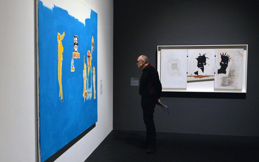 A visitor looks at Jean-Michel Basquiat's ''King Zulu'' at the ''Basquiat. Boom for Real'' exhibit at the Schirn Kunsthalle in Frankfurt, Germany. The exhibit runs until May 27, 2018. At right is ''Self-Portrait.'' Artworks: © VG Bild-Kunst Bonn, 2018 & The Estate of Jean-Michel Basquiat, Licensed by Artestar, New York. 