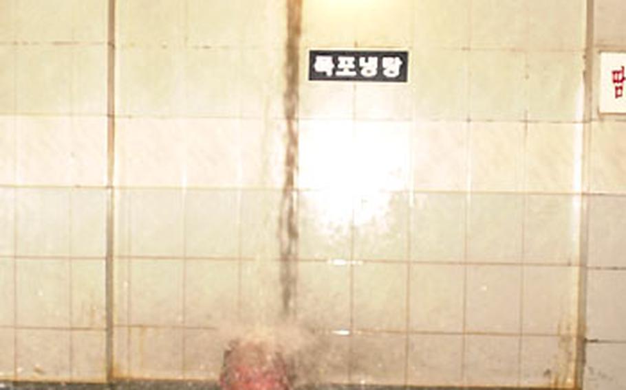 A man relaxes under a jet of water spraying from the ceiling into a pool at the Seolbong Onchon Tourist Hotel.