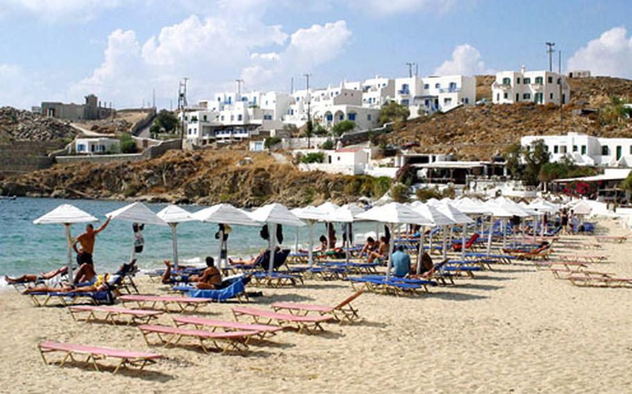 White umbrellas and white-washed homes add to the charm of one of the beaches of Mykonos.
