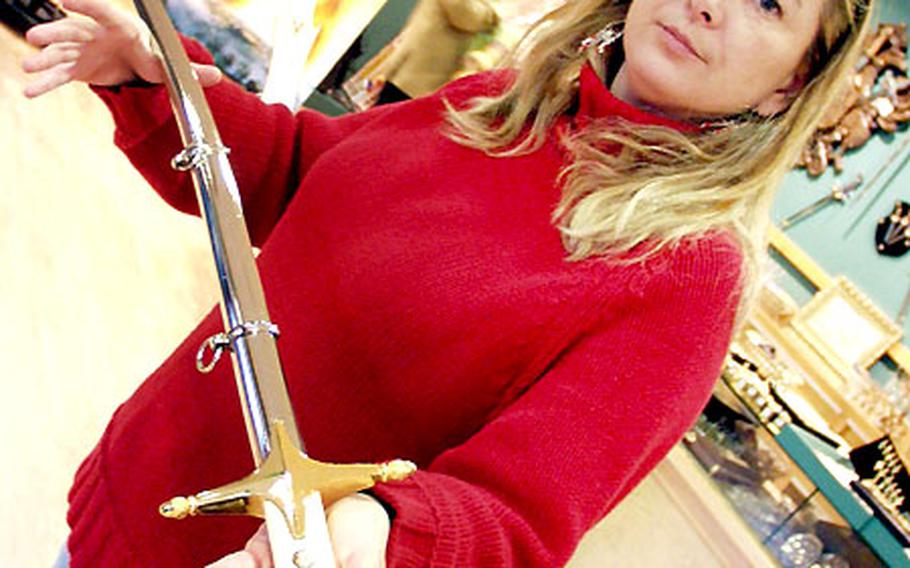 Elena García Maeso, a sales representative for Swords from Toledo, holds a U.S. Marine Corps ceremonial sword from her family’s shop in Toledo, Spain.