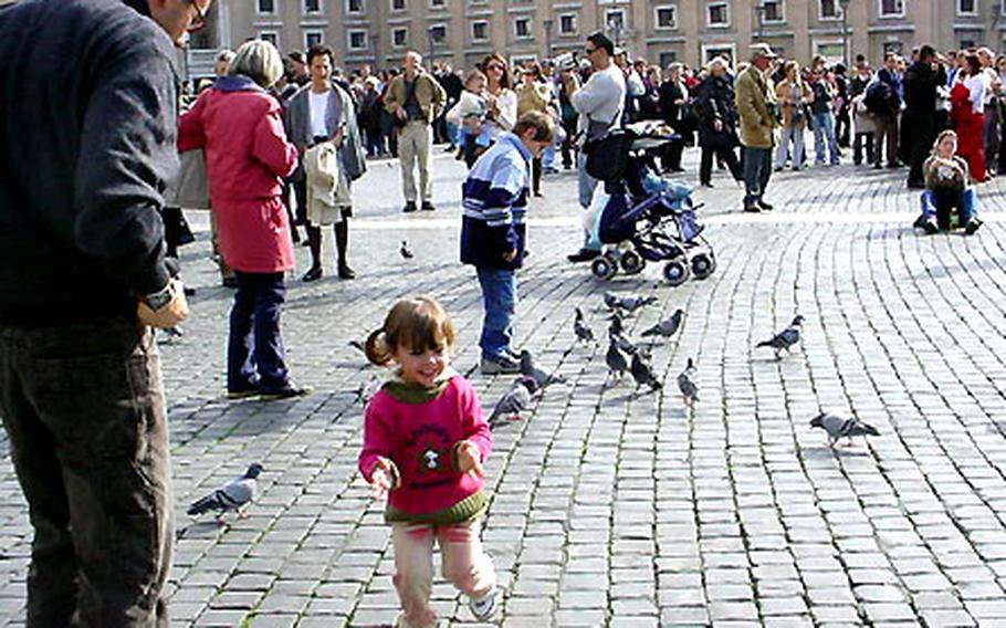 A child joyfully toddles amid the ever-present pigeons in St. Peter’s Square in Rome.
