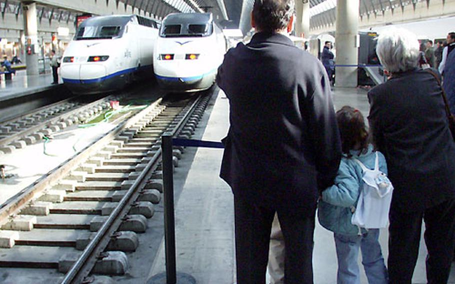 A couple with their granddaughter wait to board Spain&#39;s bullet train, The AVE, in Seville.
