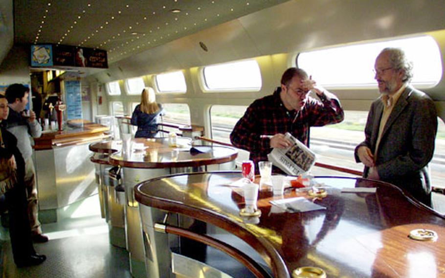 Passengers chat inside the “barcar,” or cafeteria section of Spain’s high-speed train from Seville to Madrid.