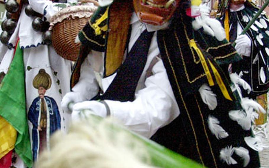 A “Federahannes,” one of the figures of the “Narrensprung” in Rottweil comes in to tease a spectator with a calf’s tail at the end of his pole. The event takes place every Rosenmontag at 8 a.m.and is repeated on Fat Tuesday at 8 a.m. and 2 p.m.