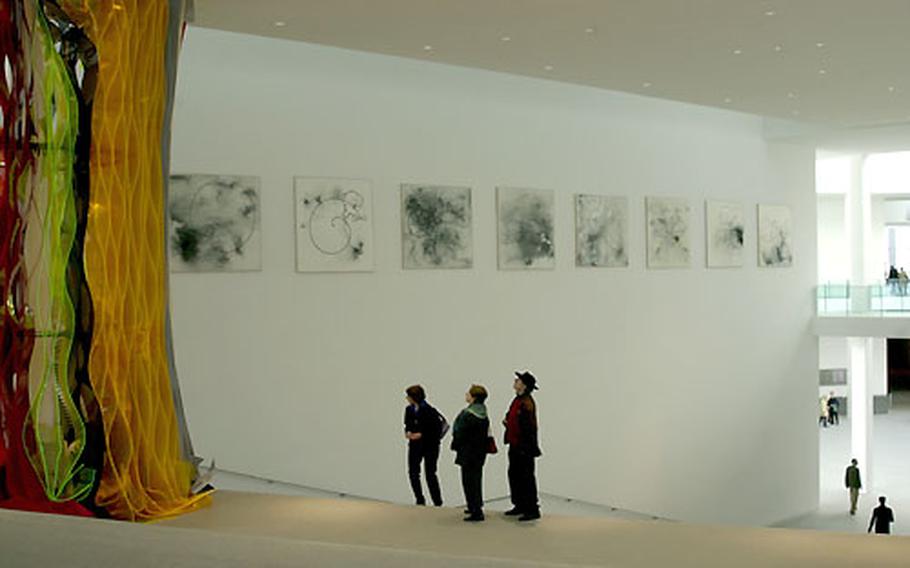 Visitors to the Pinakothek der Moderne look at art displayed on the museum’s giant staircase.