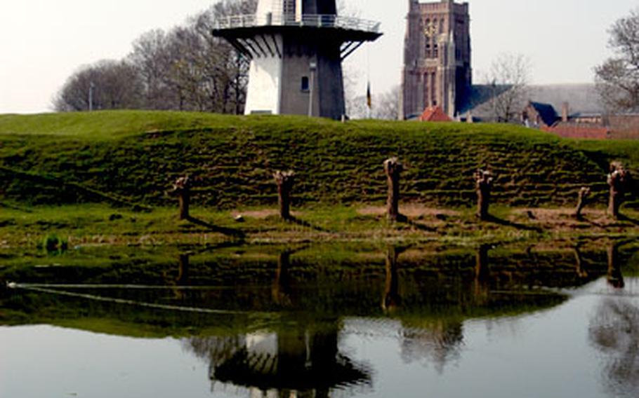 Woudrichem’s windmill and Martinus church are reflected in the moat on the south side of this Dutch medieval town.