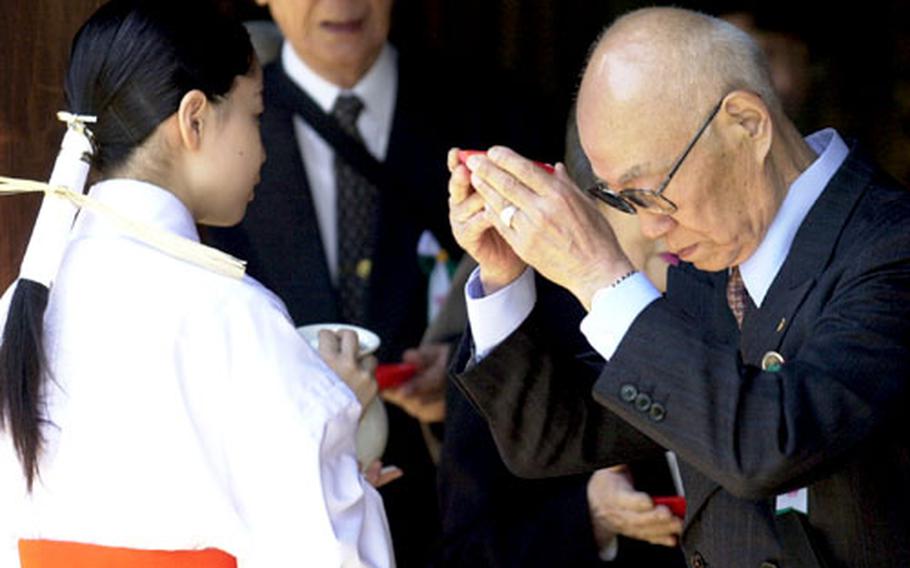 A man offers a communion of sake in a Shinto ritual.