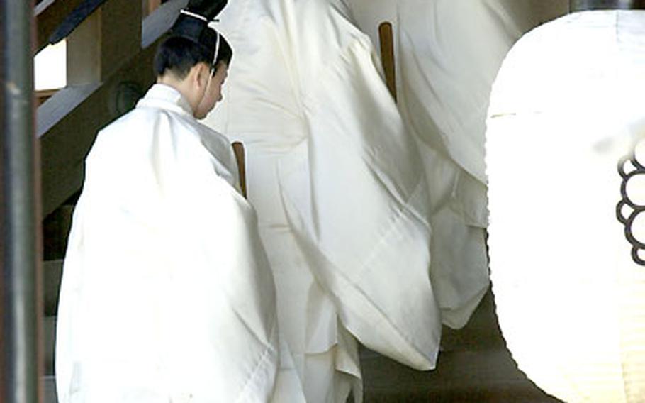 Shinto priests walk into the main hall of worship at the Yasukuni Shrine during the Great Spring Festival.