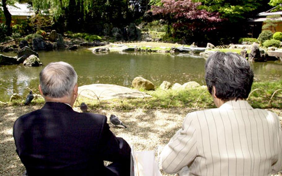 A Japanese couple enjoys the afternoon next to a pond at the Yasukuni Shrine in Tokyo. The pool of water was built and dedicated to those who died of thirst on battlefields.