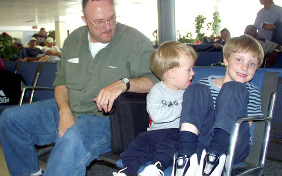 Navy Chief Petty Officer Lauren Blakley and his sons, Camden, 2, and Conor, 6, wait for a Space-A flight from Naval Station Rota, Spain, to the United States recently. Blakley is stationed in Sigonella, Sicily.