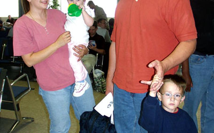 Navy Petty Officer 3rd Class Eric Chapman, wife, Brandi, and children Cameron, 4, and Holly, 18 months, get in line to take a Space-A flight from Naval Station Rota, Spain, to the United States on May 13. The Chapmans are stationed in Sigonella, Sicily.