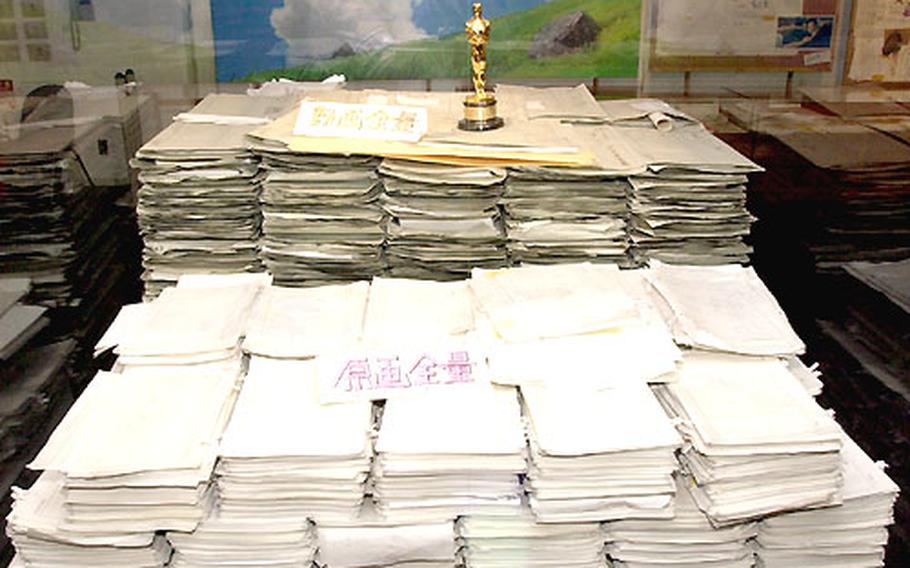 Atop the large pile of raw sketches for the movie “Spirited Away” sits the Oscar the movie won for “Best Animated Feature Film.”