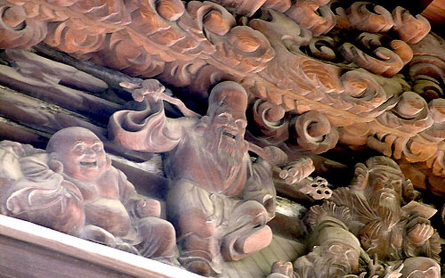 A close-up of the wood carving above the entrance of the 1929 public bathhouse which represents "The Seven Gods of Fortune."