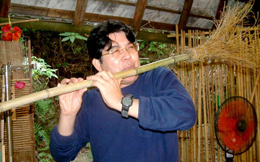 Kinya Tamaki plays a version of “Amazing Grace” on this bamboo broom flute. He sells handmade slide whistles and flutes at the Ryukyu Mura folk village.