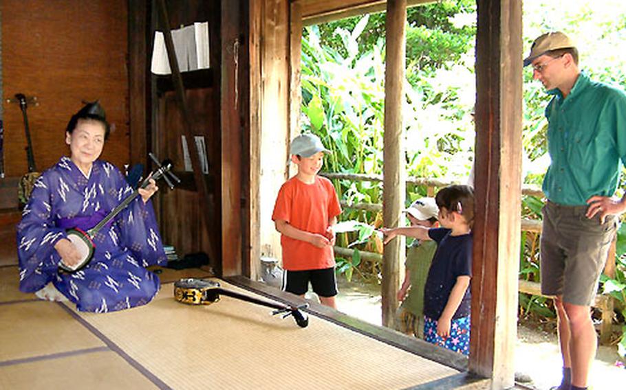 Tomiko Shimabukuro plays the sanshin for a family from Tokyo visiting Ryukyu Mura, a folk village sometimes referred to as Okinawa’s Williamsburg.