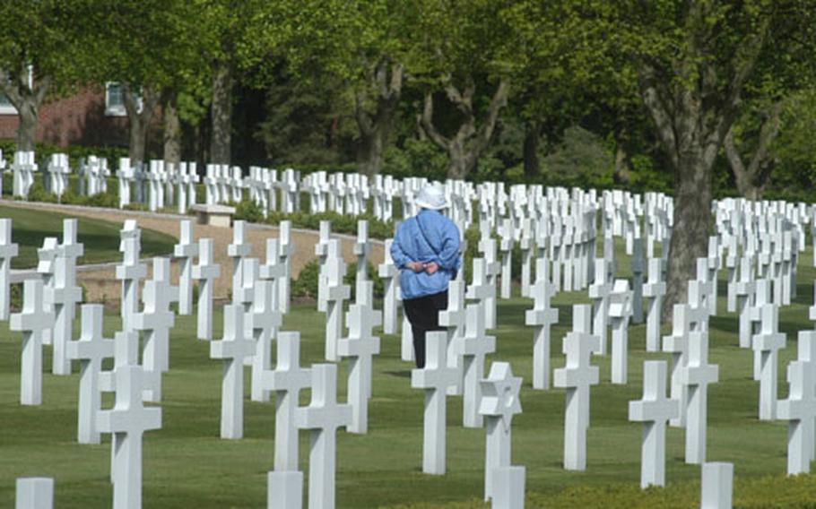 A visitor walks among the grave markers at Cambridge American Cemetery in England. More than 3,800 American war dead from World War II are buried at the cemetery near Cambridge, England.