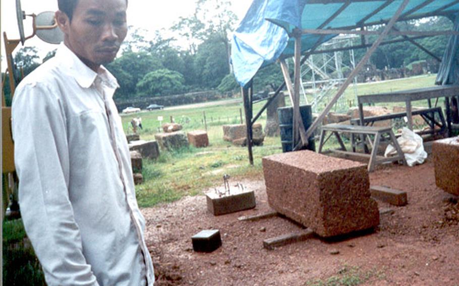 Tuan, 20, stands near temple group undergoing restoration compliments of Japanese donations.