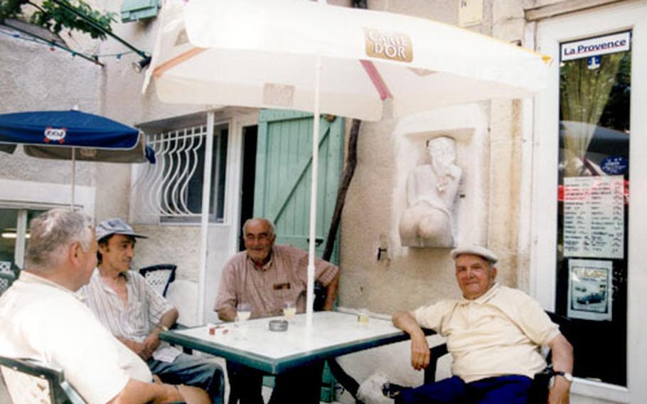 Village locals gather at an outdoor café under the sculpture of “Fanny." They often play a game in which the loser has to kiss Fanny on the fanny.