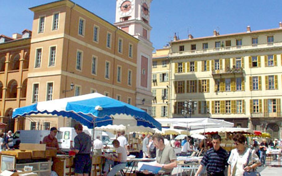 Peddlers sell old photos and books in a market in Nice, France.