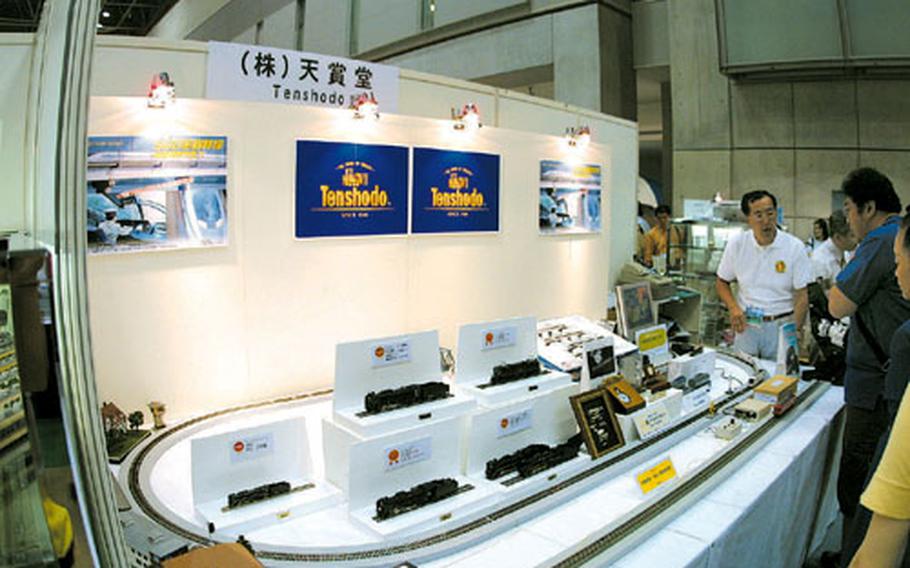 Precision brass models are displayed at booths run by manufacturers including Tenshodo, Katsumi, Endo, etc.