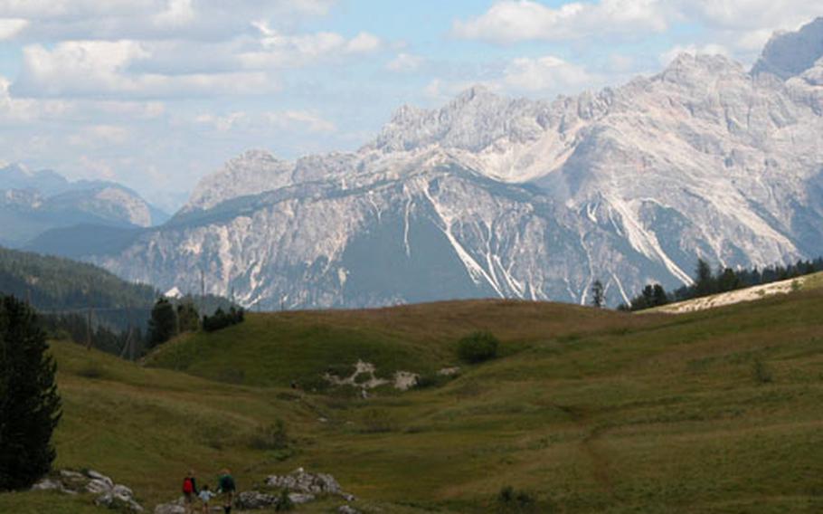 A family strolls through a valley at Passo Falzarego, near Cortina, northern Italy.