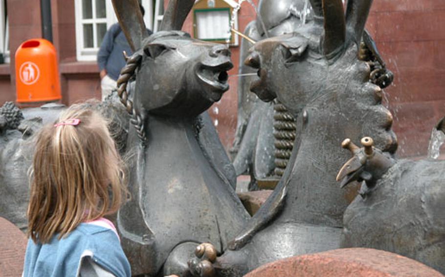 A little girl admires the donkey couple, part of the Emporer&#39;s Fountain at Mainz Gate in downtown Kaiserslautern.