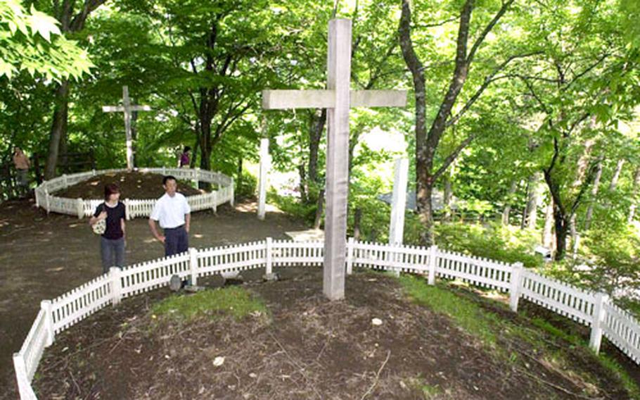 Visitors pause at the purported grave of Christ in Shingo, Japan. Behind them is the supposed grave of Jesus&#39; brother, Isukari.