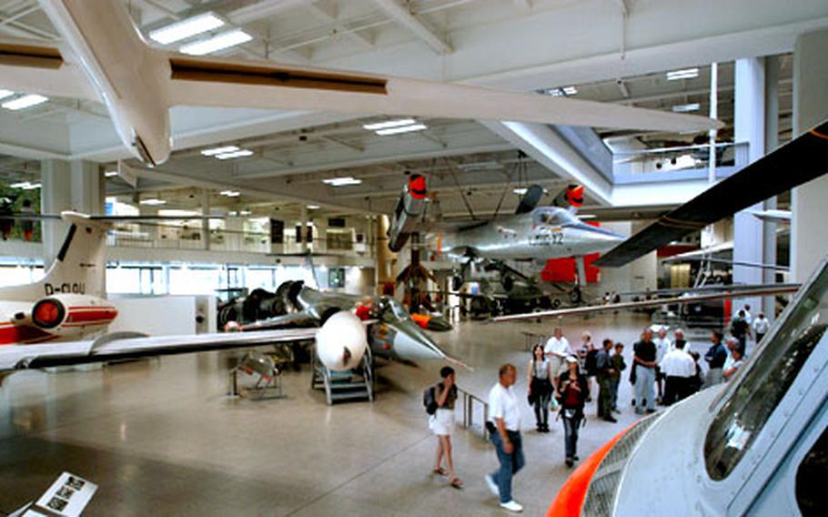 Visitors check out aircraft in the aviation hall of the Deutsches Museum.