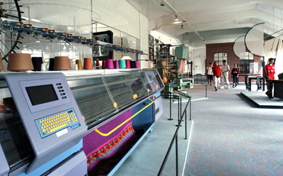 An automated loom weaves a carpet in the textiles department at the Deutsches Museum.