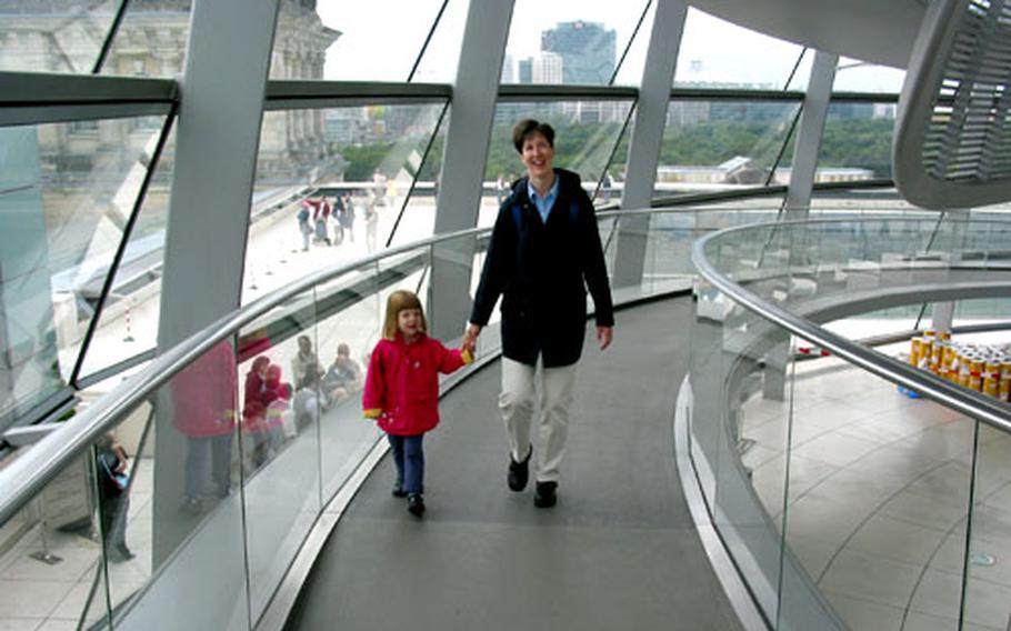 Mother and daughter amble along the walkway in the glass dome of the Reichstag in Berlin.