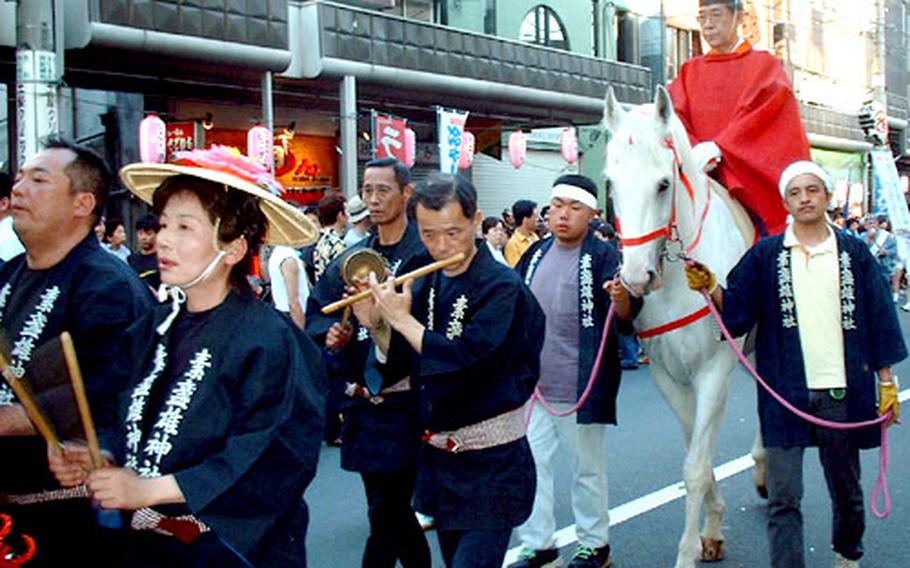 The Chief Priest of Susanoo Shrine in Minami-Senju, Tokyo, leads a mikoshi parade on a white horse.