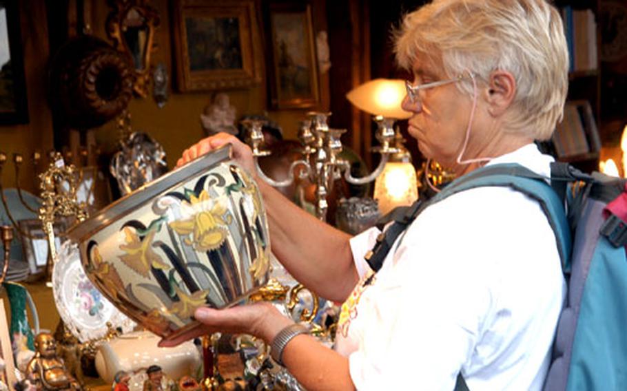 A visitor to the Auer Dult in Munich checks out the condition of an antique vase at one of the stands. The Dult — an old word for a church festival — takes place in the Munich neighborhood of Au three times a year.