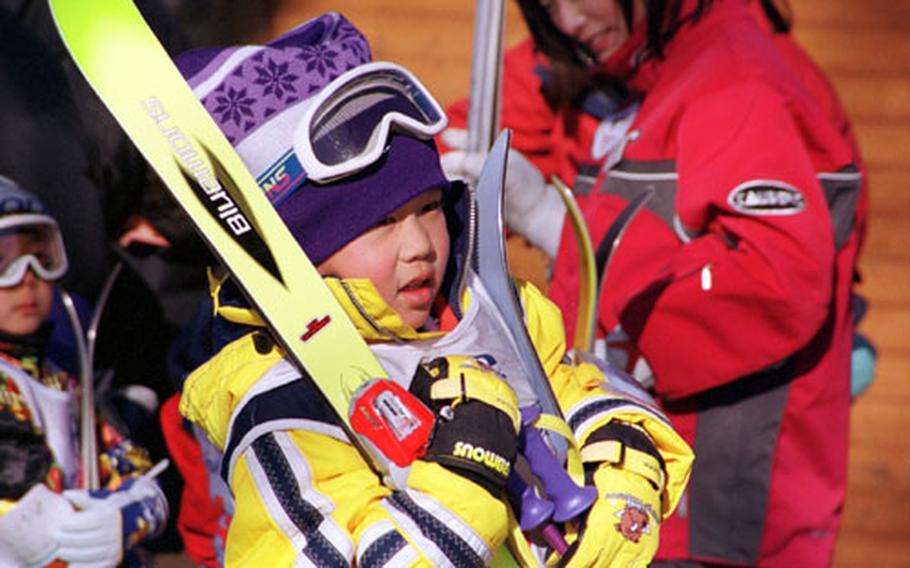 A child struggles to carry his gear to a children’s ski class at the Karuizawa Prince Ski Resort.
