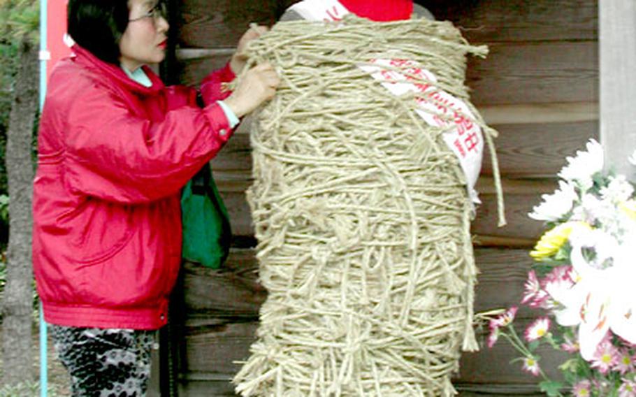 Tomoko Takasawa, 55, visits Nanzoin Temple to tie a rope on Shibarare Jizo (tied Jizo) and pray for her health.
