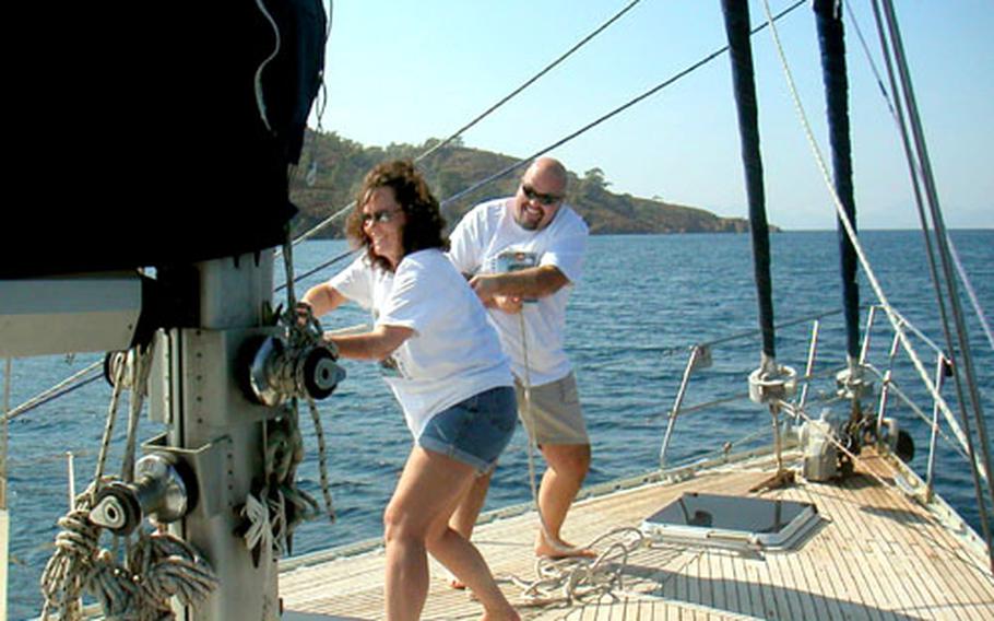 Angela Guthrie and Bruce Rehberg hoist the main sail of the Anna Maria as it sets from the port of Fethiye, Turkey.