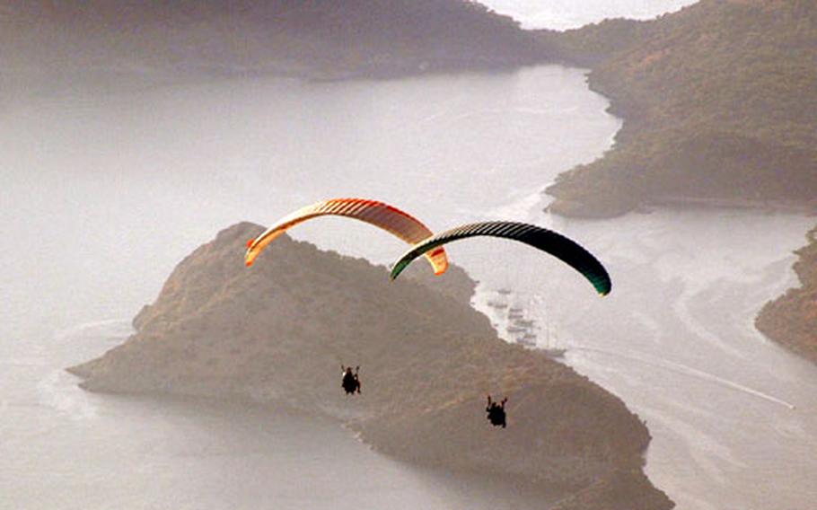 Paragliding over the Ölüdeniz area in southern Turkey are group member Bruce Rehberg, left, and the Anna Maria’s first mate, Jill Lumenta.