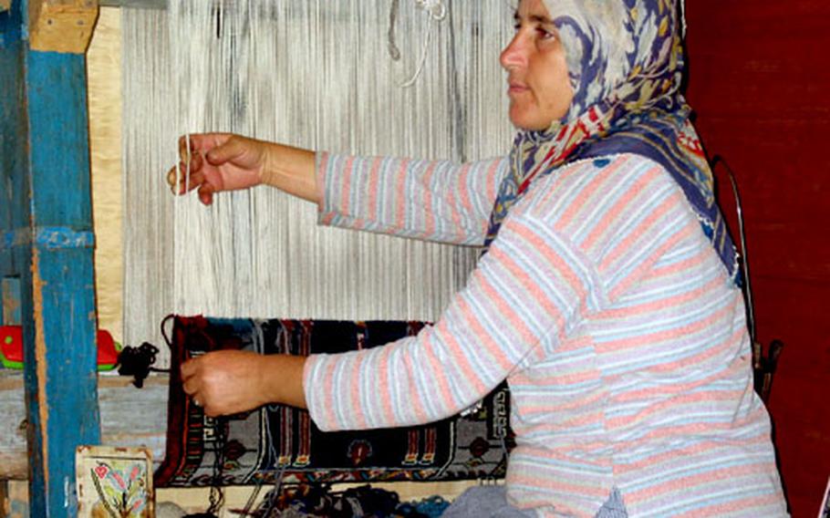 A member of the Kül family shows the sailing group how to weave a Turkish carpet while they visit her home above Kapi Creek, near the town of Göcek, Turkey.