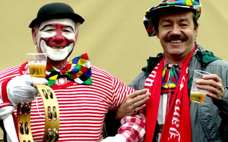 Colorful clown characters hoist a brew at Fasching celebrations in Cologne, Germany.